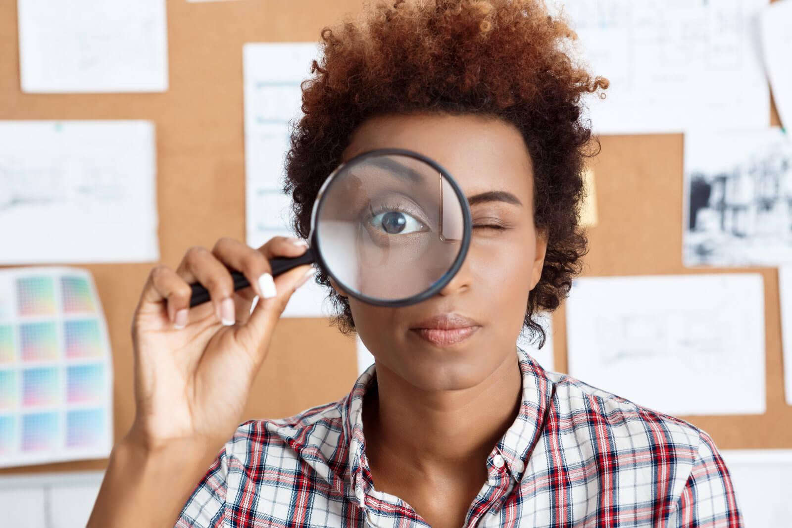 woman looking in magnifier glass